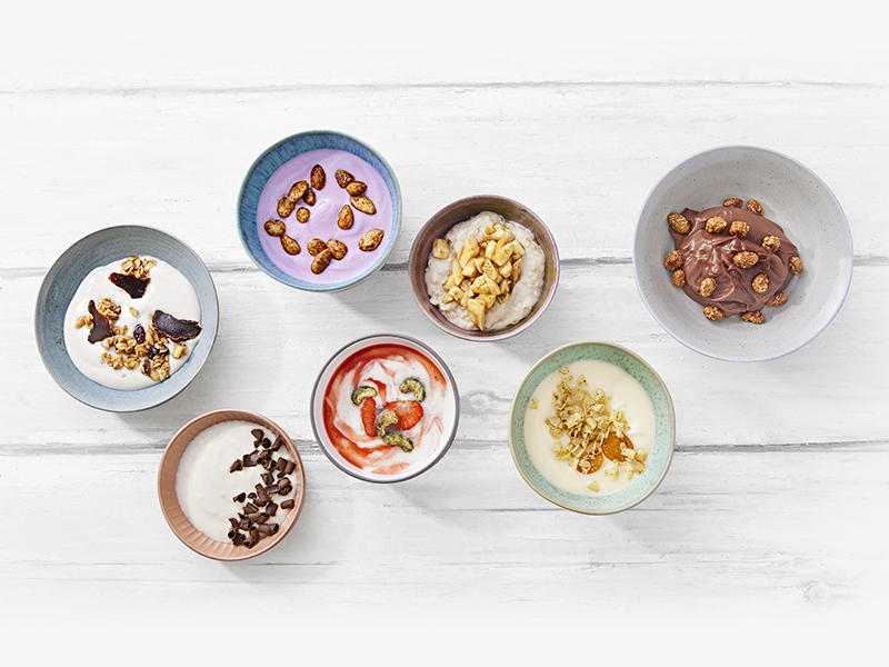 Sieben verschiedene Desserts mit MILRAM Produkten, darunter MILRAM fettarmer Joghurt mild sowie MILRAM Fruchtjoghurt mild in den Sorten Mango, Banane und Heidelbeere 