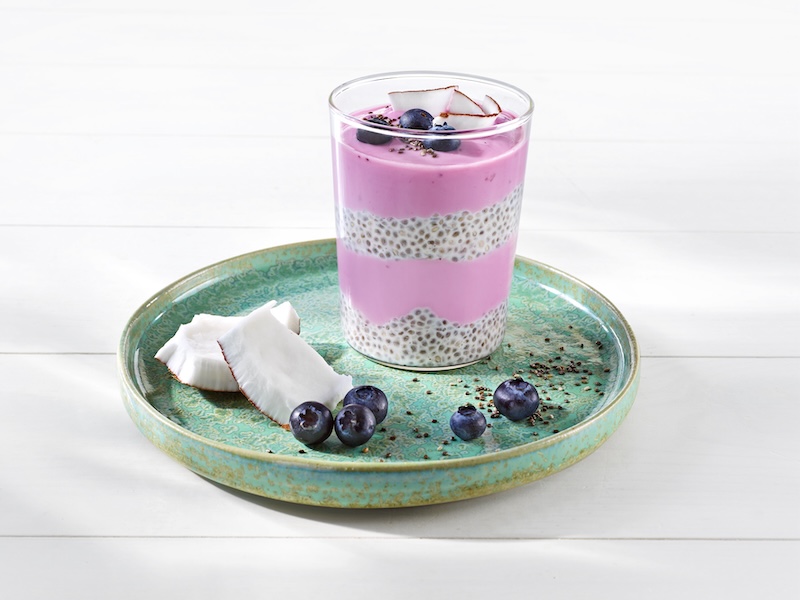 MILRAM Fruchtjoghurt mild Heidelbeere und in Kokosmilch eingelegte Chiasamen geschichtet in einem Glas 