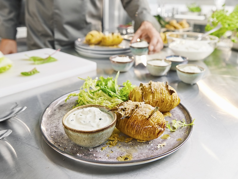 Teller mit zwei Fächerkartoffeln, Salatbeilage und einem Schälchen mit MILRAM FrühlingsQuark
