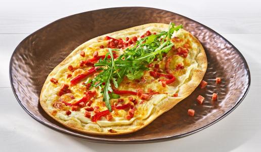 Flammkuchen mit Sucuk, gedörrter Paprika und Rucola